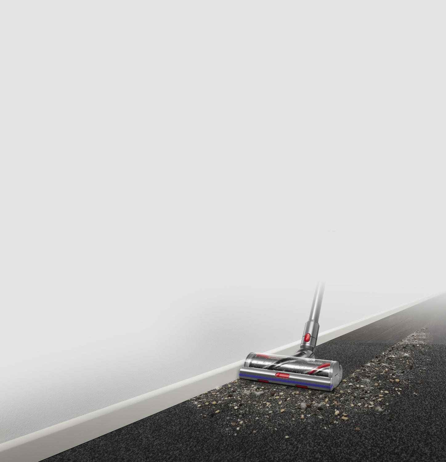 Dyson V11 vacuum cleaning hard floors and carpet along a wall